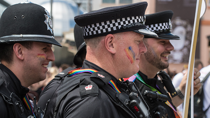 Police smile with rainbows painted on their cheeks