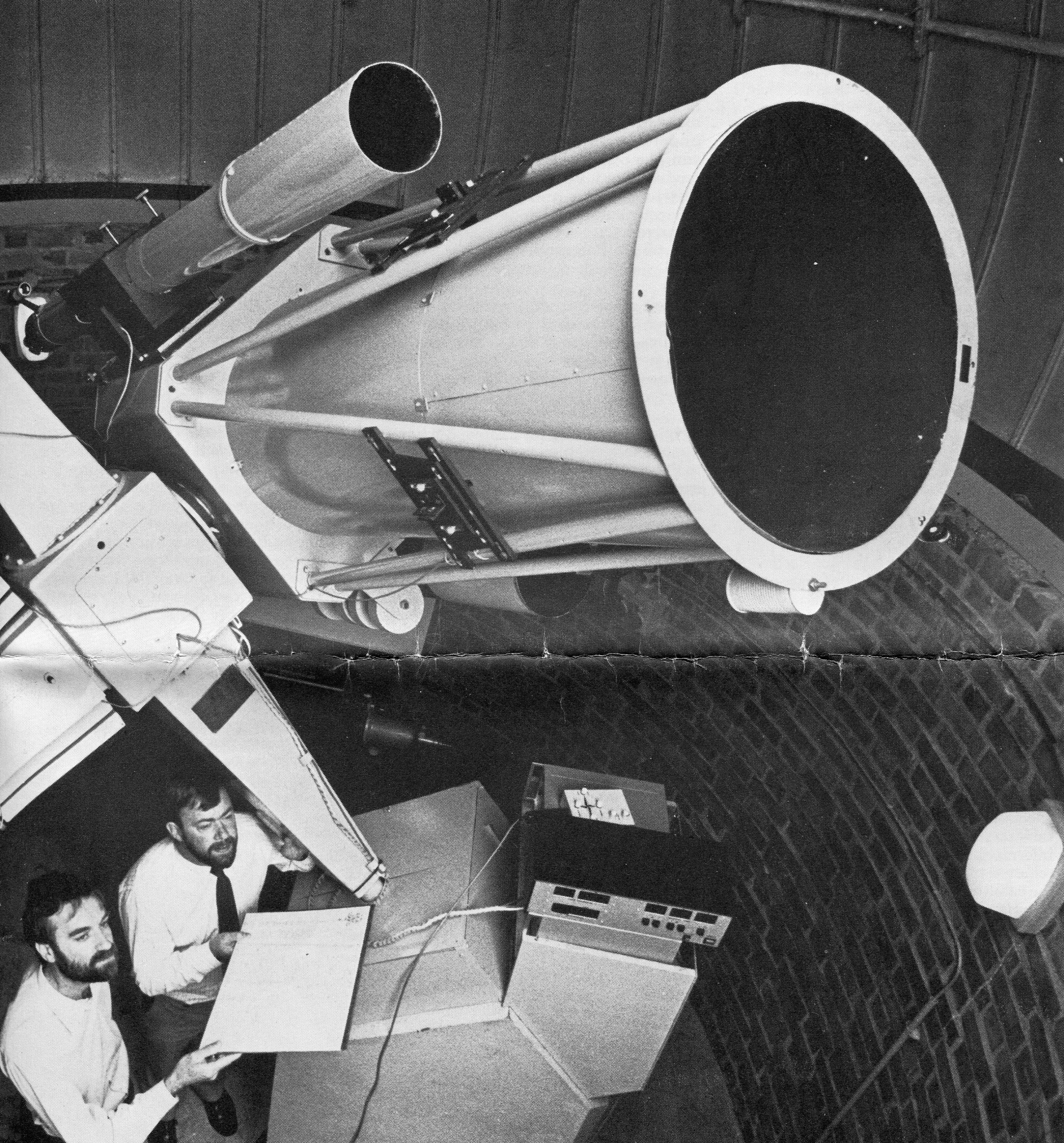 Two astronomers using a telescope