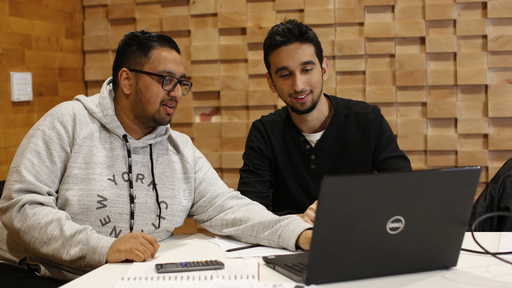 Two male students using laptop