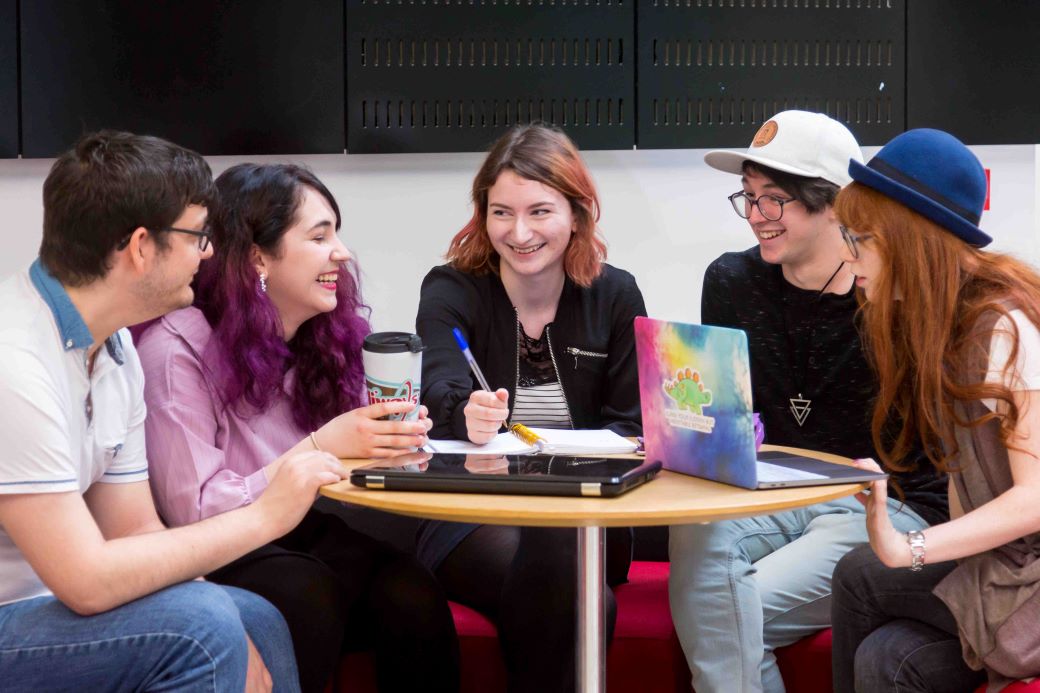 students relaxing and chatting round a table. 