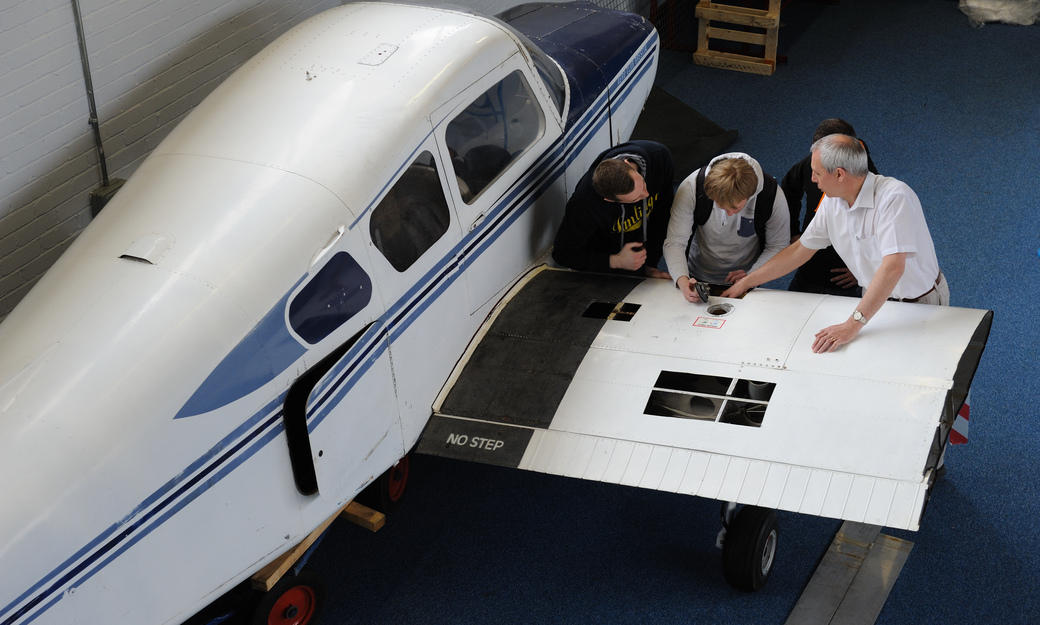 a group of students looking at the different components of an aircraft