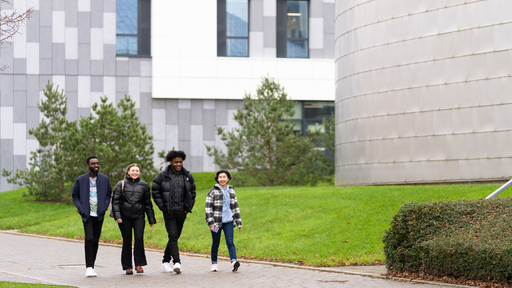 Image of happy students walking across campus