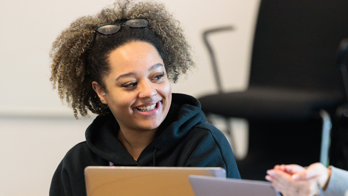Image of a female student smiling with a laptop