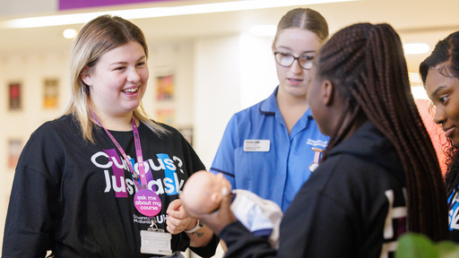 Image of a staff member helping students at an open day