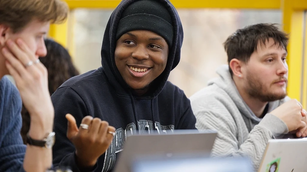 A student talking and pointing to another student