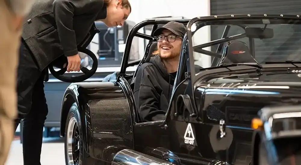 A student in a built kit car
