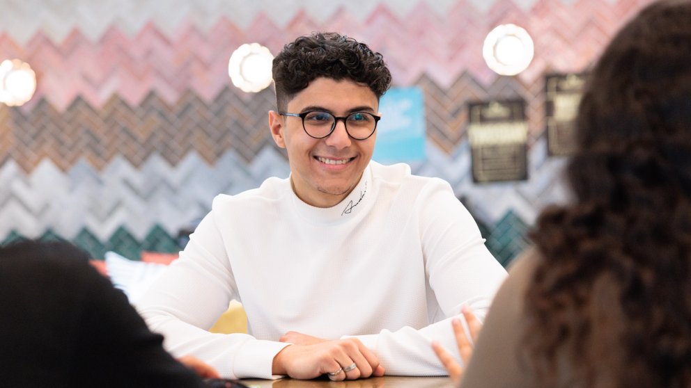 A person smiling in a while jumper