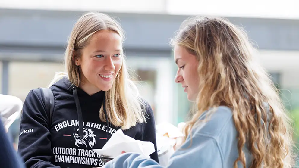 Two students talking and smiling