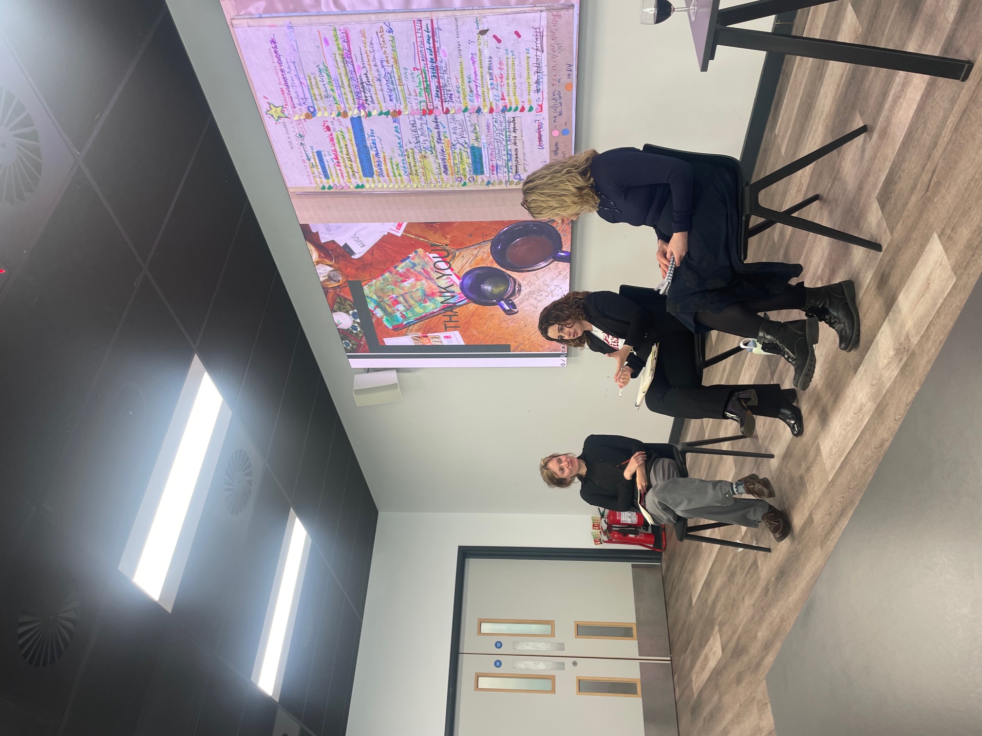 Three women sitting on chairs in discussion