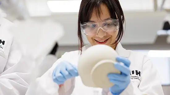 Student in a lab coat with a dish