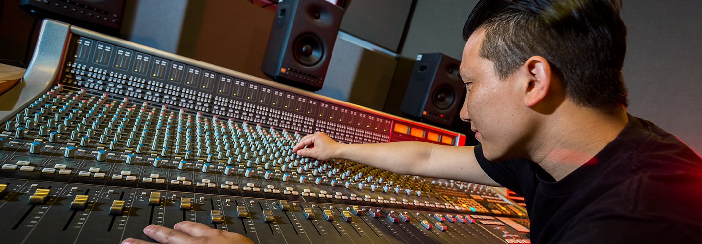 Male student using mixing deck