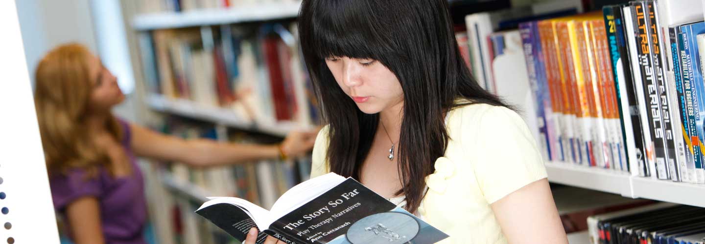 Student reading book in library