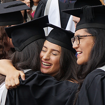 Two graduates hugging