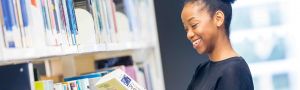 student looks at a philosophy book in the library