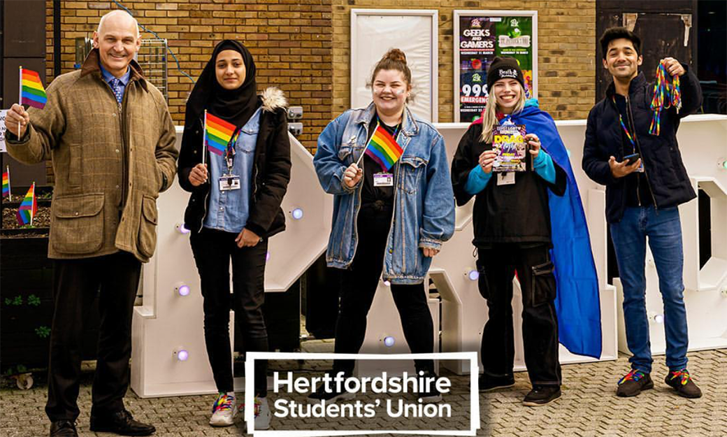 The Vice-Chancellor and students from the LGBT+ Society wave rainbow flags