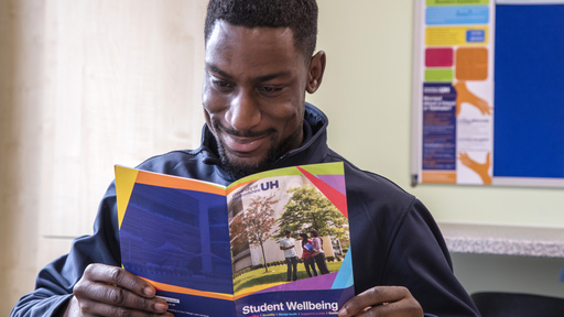 Black male student reading leaflet