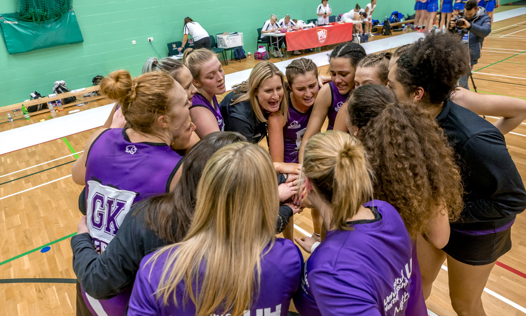 the Herts netball team completing a hands in affirmation before returning to play