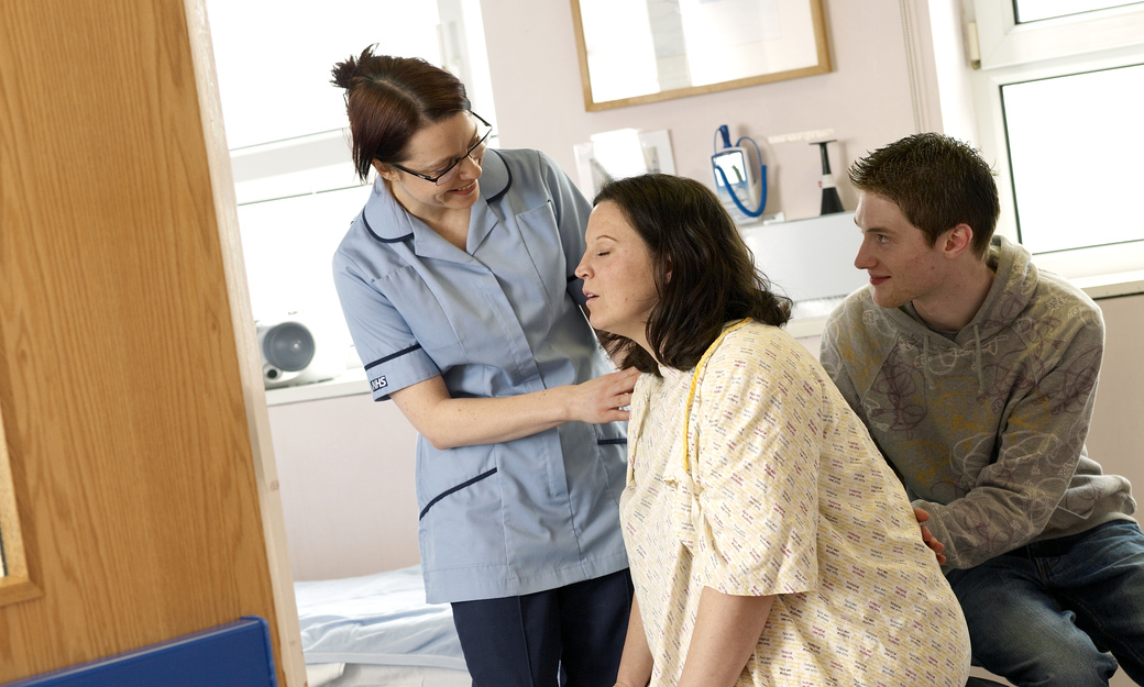 a student midwife supporting a couple, with the woman in the early stages of labour 