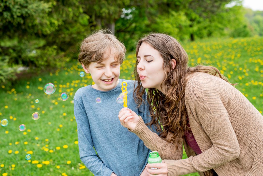 a student blowing bubbles for a child with special needs