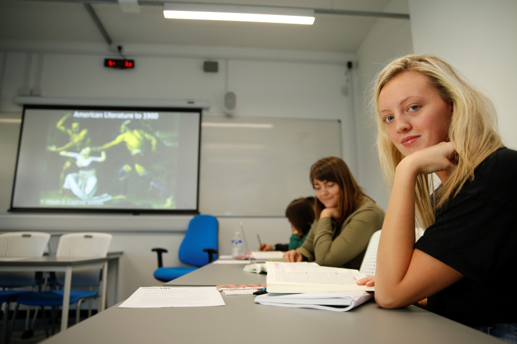 a student in class looking at the photographer, smiling 