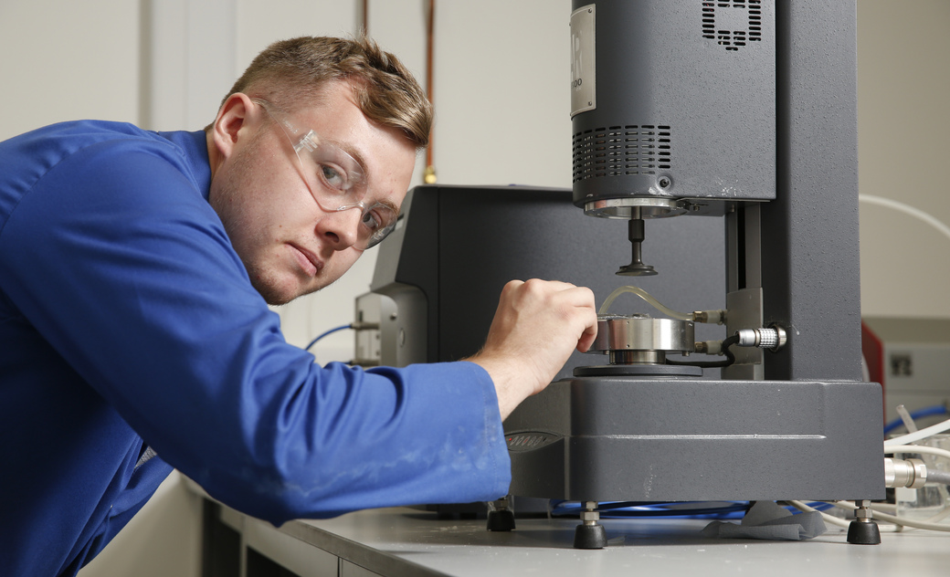 a male student operating a piece of equipment in the lab