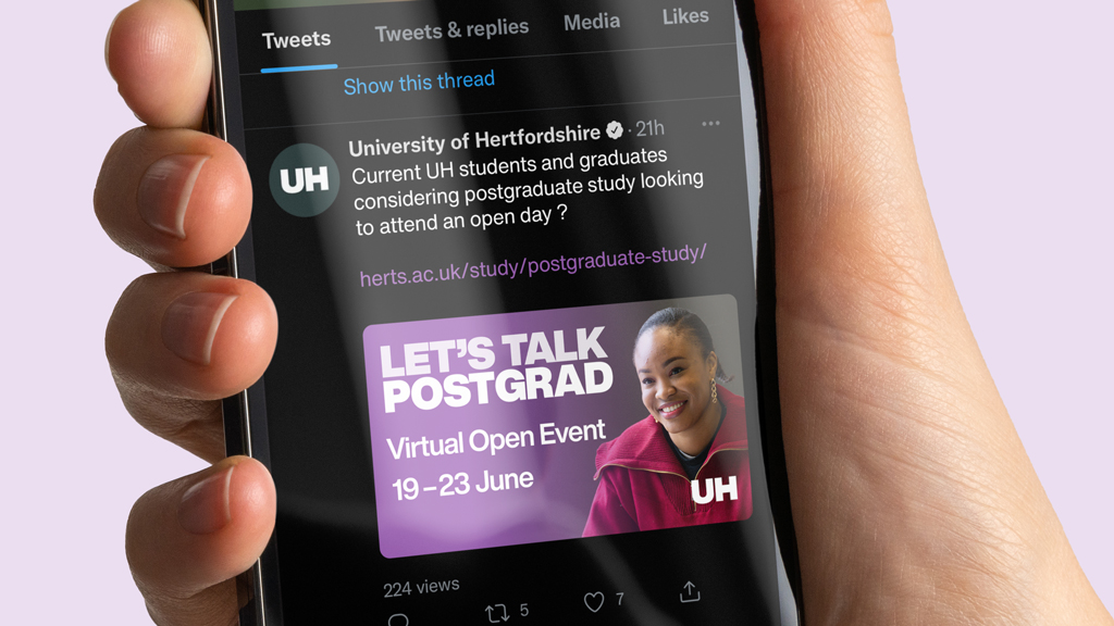 An iPhone with Twitter open, displaying a post about Postgraduate study at the University of Hertfordshire