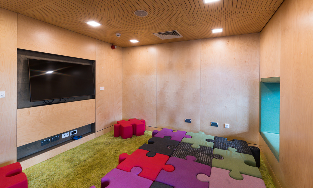 Communal cosy relaxation area with floor pillows and a TV