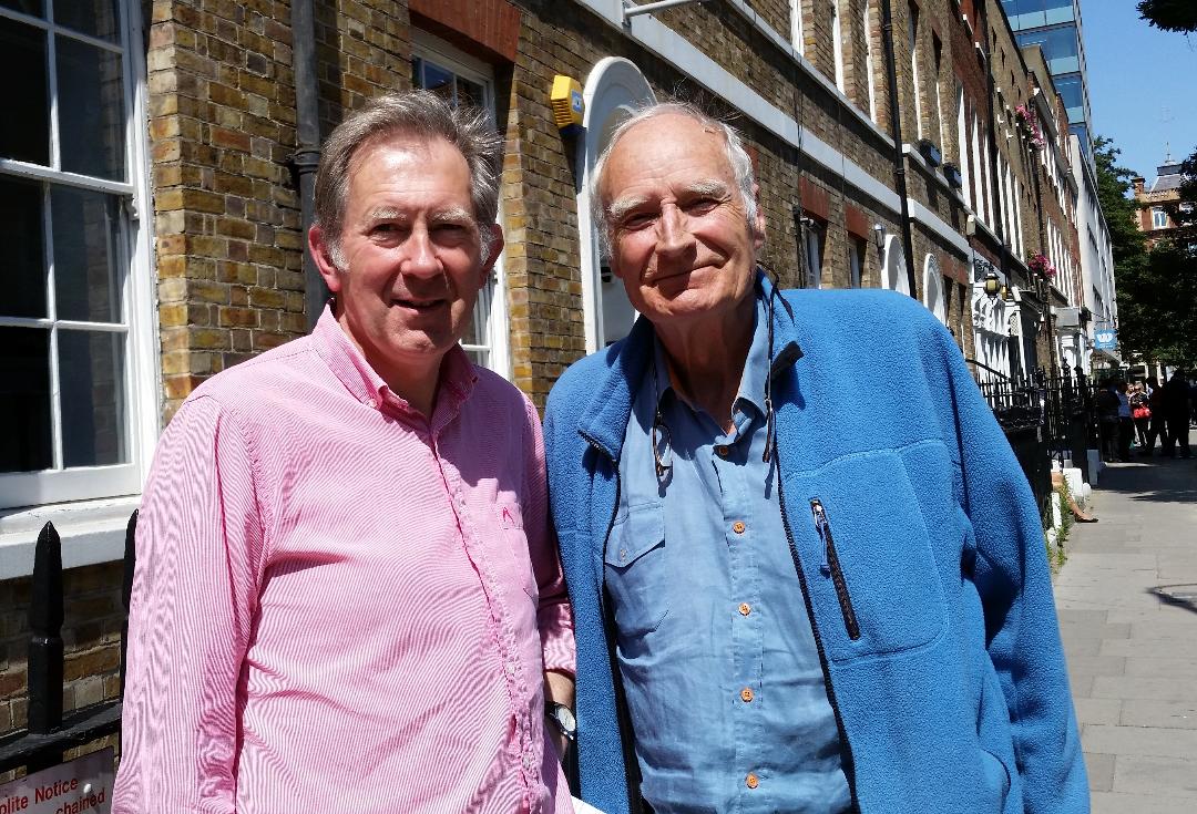 Two men in light shirts looking at the camera.