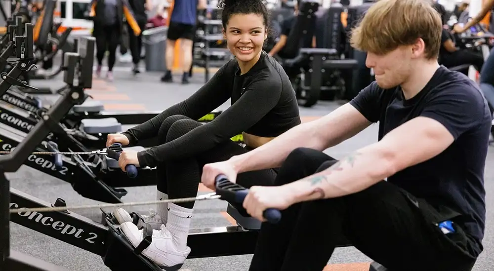 Two people on a rowing machine