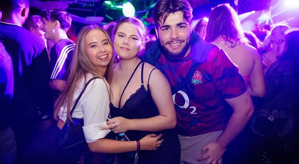 Three students posing for a picture in the University nightclub