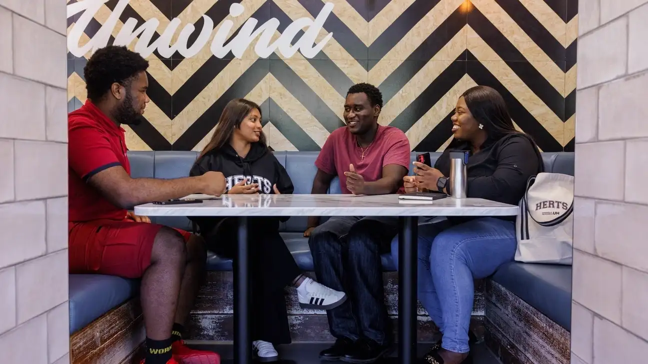 Students sitting down on sofa benches in Subway