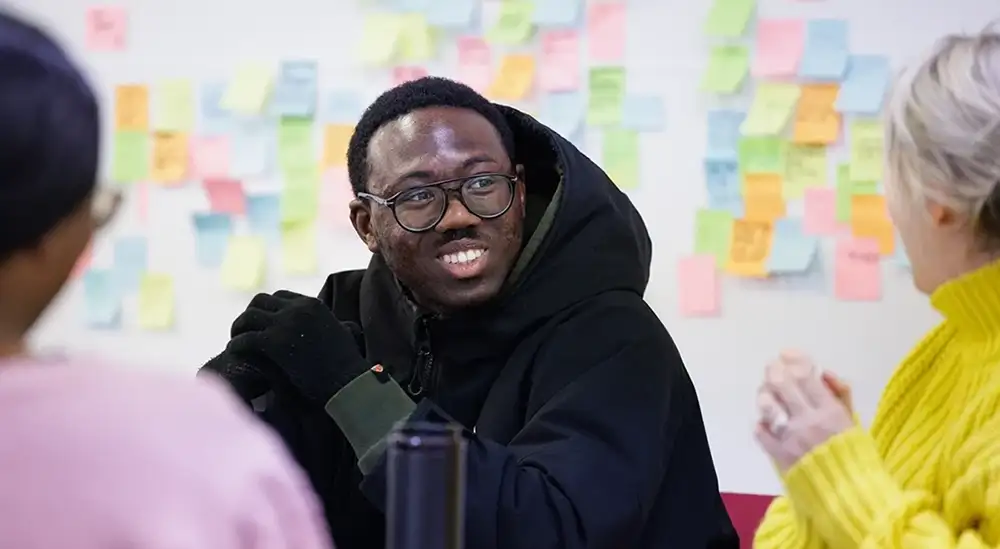 A student smiling in a black jacket