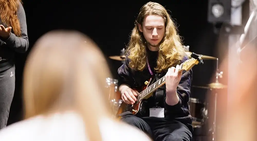 A student playing a guitar