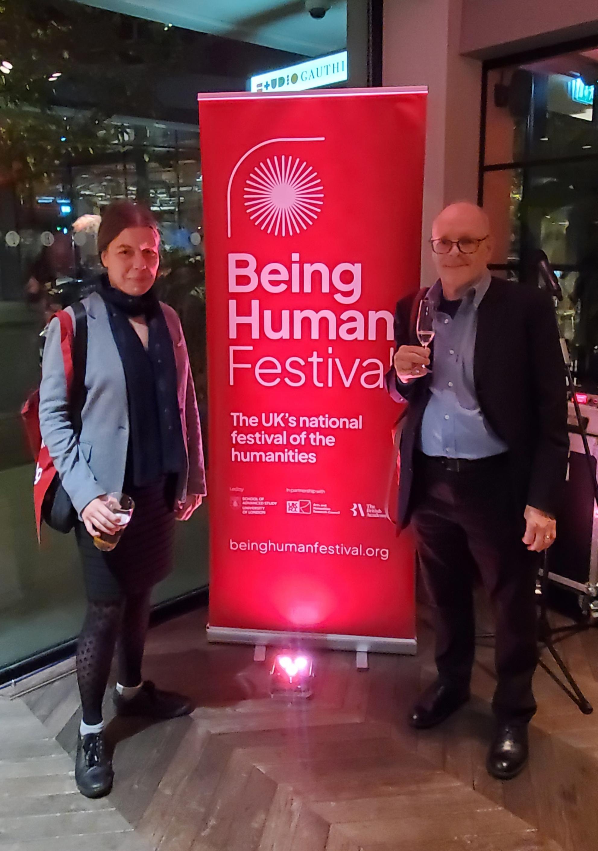 Jonathan Morris and Katrina Navickas in front of a banner