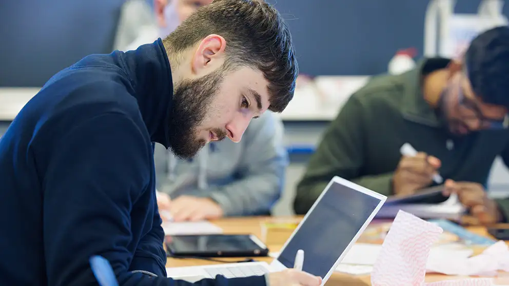 Student sitting at a table in front of a laptop