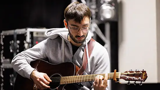 A student playing the guitar
