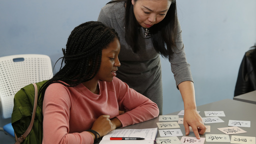 Chinese teacher helping female student with languages
