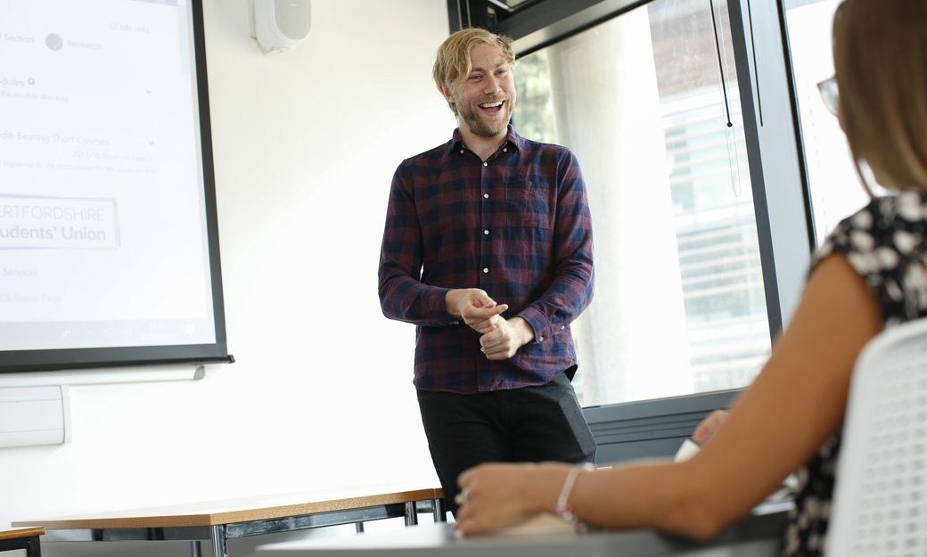 a student and lecturer laughing together in class