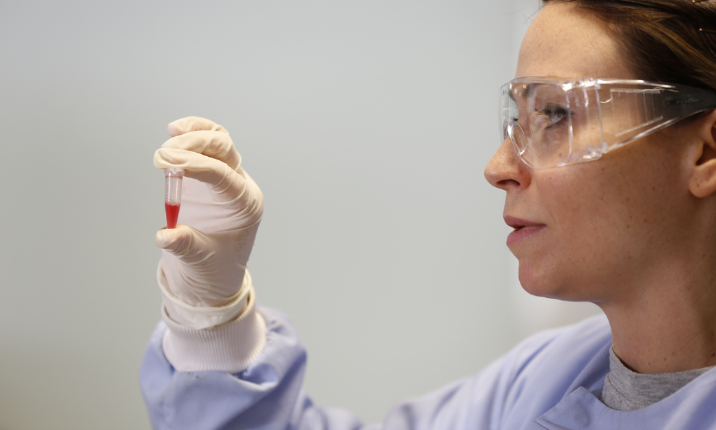 a student looking a a sealed vial of blood 