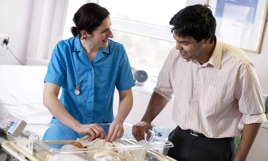 a student midwife undertaking a simulation of introducing a father to their baby. 
