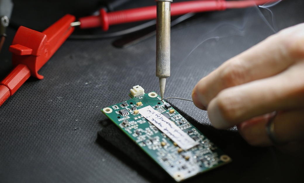 a student soldering components to a circuit board 