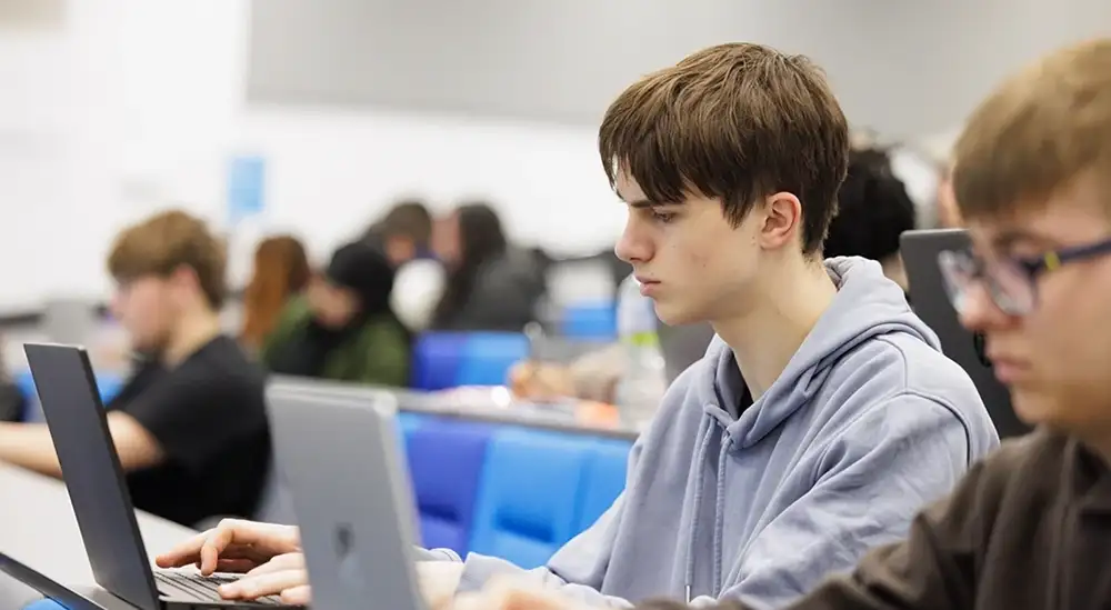 Two students sitting on a laptop typing