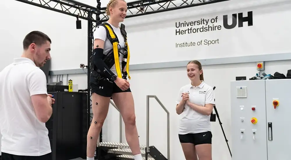 A clos up of a aperson on a treadmill with a student either side