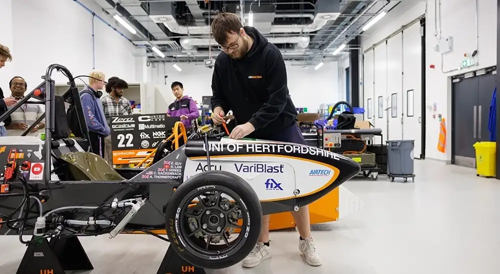 A stundent mending the front end of a car