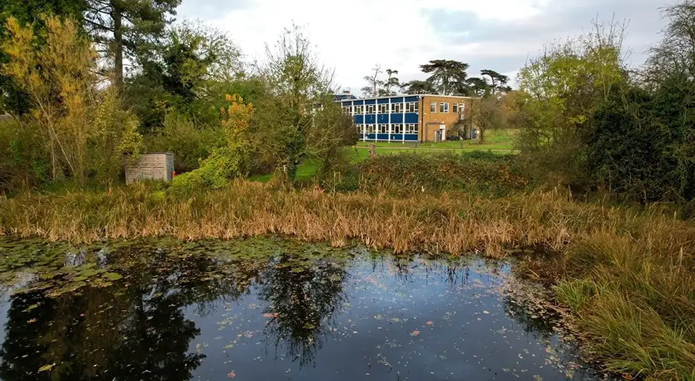 Lake in the foreground with campus building in the background
