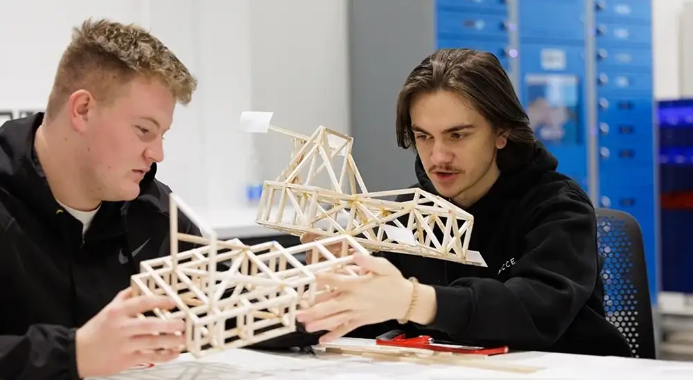 A group of students building a wooden model