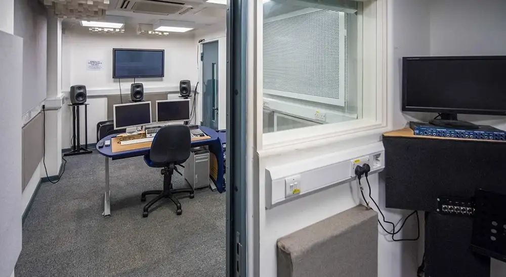 A dubbing studio with comuters and sound equipment in it