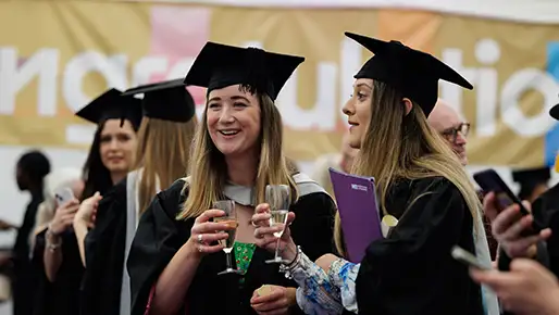Student at graduation drinking a celebratory drink