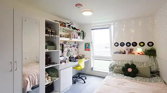 Waredrobe, bed and desk with laptop