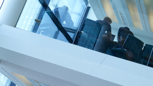 Group of students meeting behind glass wall